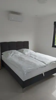 a bed in a room with a white wall at Casa Aurelia in Gornji Štoj