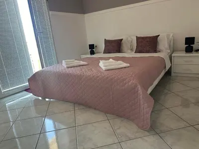 a bedroom with a large bed with two towels on it at TIA Sveti Stefan in Budva