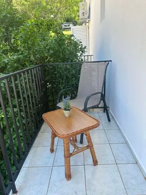 a wooden table and a chair on a balcony at TIA Sveti Stefan in Budva