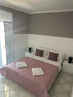 a bedroom with a large bed with two towels on it at TIA Sveti Stefan in Budva