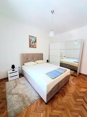 a bedroom with a large bed and a mirror at N&B Apartment Kotor in Kotor