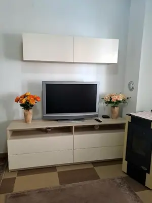 a television sitting on a cabinet in a living room at N&B Apartment Kotor in Kotor