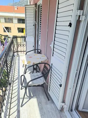 a balcony with a table and a chair on a porch at N&B Apartment Kotor in Kotor