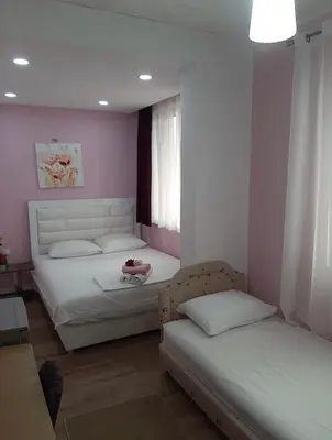two beds in a room with pink walls at Riian Luxury Apartments in Ulcinj