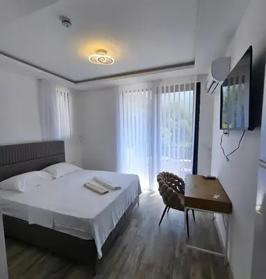 a bedroom with a bed and a table and a window at La Vida Apartments in Babalonija