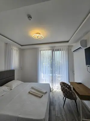 a bedroom with a bed and a desk and a window at La Vida Apartments in Babalonija
