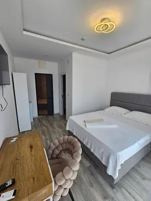 a bedroom with a large bed and a table at La Vida Apartments in Babalonija