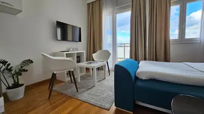 a hotel room with a bed and a table and chairs at White Sensation in Podgorica
