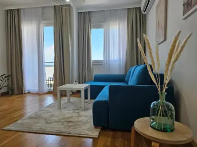 a living room with a blue couch and a table at White Sensation in Podgorica