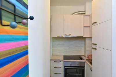 a kitchen with a colorful painting on the wall at Petra Apartment in Ulcinj