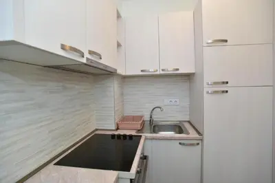 a small kitchen with a sink and a refrigerator at Petra Apartment in Ulcinj
