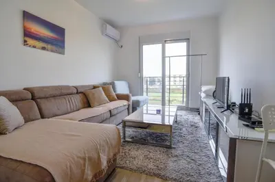a living room with a couch and a tv at Petra Apartment in Ulcinj