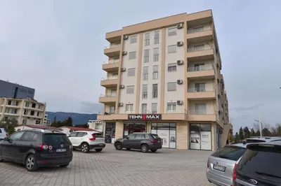 a parking lot with cars parked in front of a building at Petra Apartment in Ulcinj