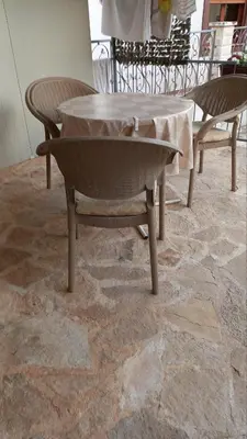 a table and two chairs on a stone floor at Milica, Soba sa kupatilom in Petrovac na Moru