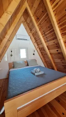 a large bed in a room with wooden ceilings at Bella Home in Rap
