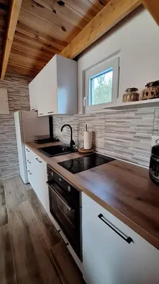 a kitchen with white cabinets and a sink and a window at Bella Home in Rap