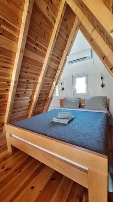 a large bed in a room with wooden floors at Bella Home in Rap