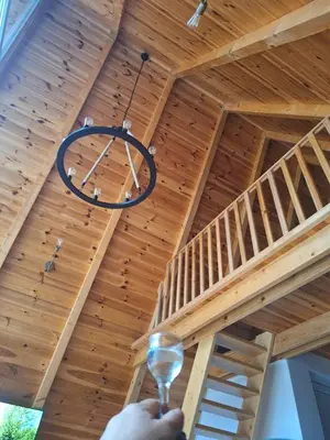 a person holding a wine glass in front of a wooden ceiling at Bella Home in Rap