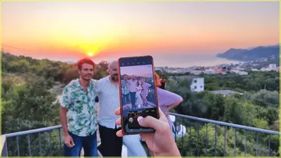 a person taking a picture with a cell phone at Montenegro Tower in Pečurice