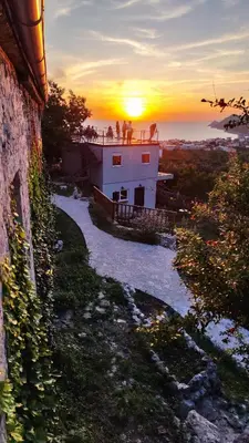 a group of people standing on a building at sunset at Montenegro Tower in Pečurice