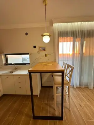 a dining room table with two chairs and a kitchen at Residence Vongola in Bar