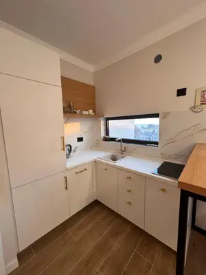 a kitchen with white cabinets and a window at Residence Vongola in Bar