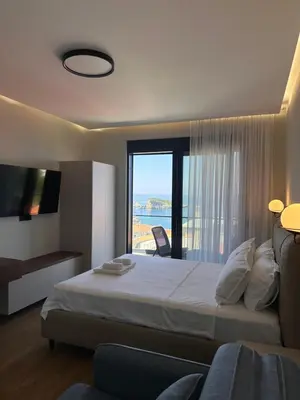 a bedroom with a large bed and a large window at Residence Vongola in Bar