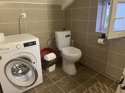 a bathroom with a toilet and a washing machine at Sea in Bar