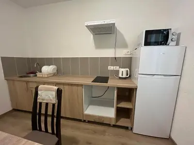 a small kitchen with a white refrigerator and a table at Sea in Bar