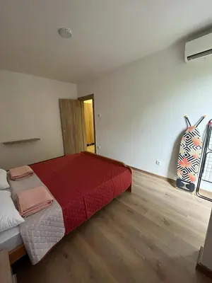 a bedroom with a large bed with a red blanket at Sea in Bar