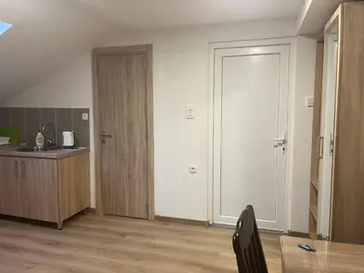 a room with a kitchen with a door and a table at Sea in Bar