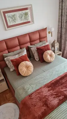 a bed with a red headboard and pillows on it at Apartment Kata in Cetinje