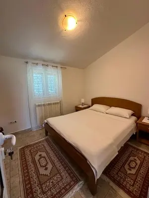 a bedroom with a large bed and a window at Apartment Maša in Radanovići