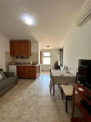 a living room with a couch and a table and a kitchen at Apartment Maša in Radanovići
