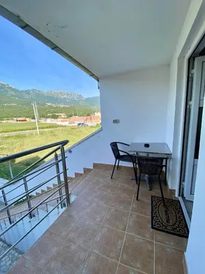 a room with a table and a balcony with a view at Apartment Maša in Radanovići