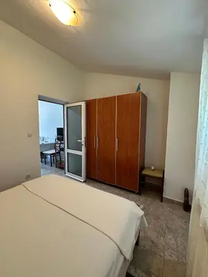 a bedroom with a bed and a sliding glass door at Apartment Maša in Radanovići