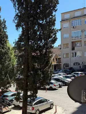 a parking lot with cars parked in front of a building at Center Square in Podgorica