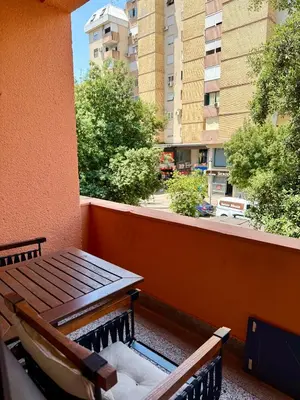 a balcony with a wooden bench and a building at Center Square in Podgorica