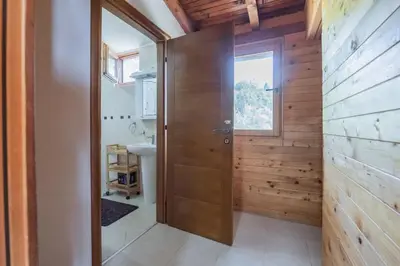 a bathroom with a wooden door and a sink at Panora Oliva in Rap