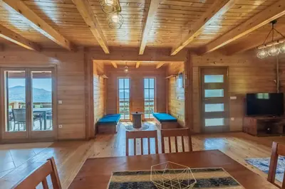 a dining room with wooden walls and a table and chairs at Panora Oliva in Rap
