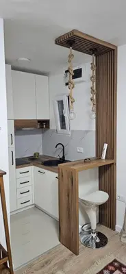 a kitchen with white cabinets and a wooden counter top at Apartman Olivera in Sutomore