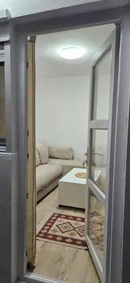 a living room with a couch and a mirror at Apartman Olivera in Sutomore