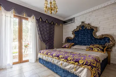 a bedroom with a king sized bed with a blue headboard at VILLA-BAROCCO Sveti-Stefan & Private Garden in Sveti Stefan