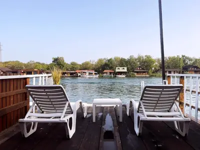two chairs and a table on a dock near the water at Sidro river house in Ulcinj
