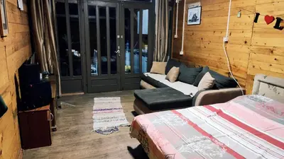 a living room with a couch and a bed in it at Sidro river house in Ulcinj
