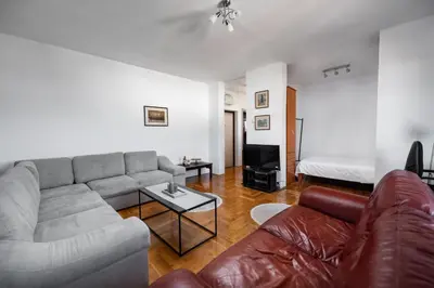 a living room with a couch and a bed at Sky Center Apartment in Podgorica