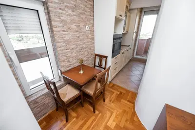 a kitchen and dining room with a table and chairs at Sky Center Apartment in Podgorica