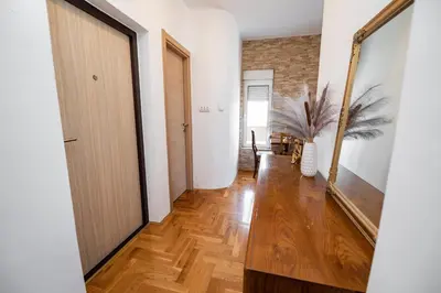 a hallway with a door and a mirror at Sky Center Apartment in Podgorica