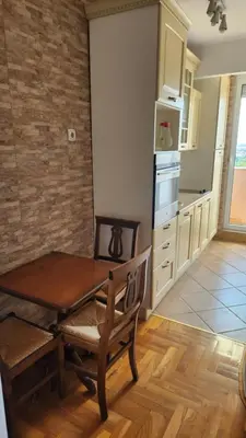 a kitchen with a wooden table and a table and chair at Sky Center Apartment in Podgorica