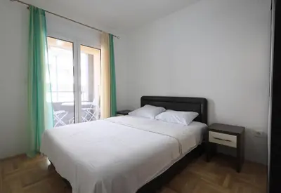 a bedroom with a large bed and a window at Status-M Apartments Rozino in Budva